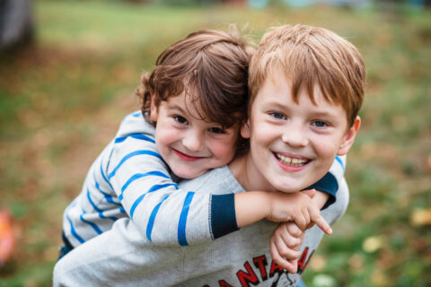 Adopted boy gives his younger brother a piggy-back